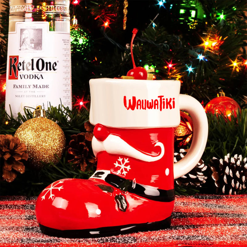 Red Santa boot mug with 'Wauwatiiki' text, Ketel One Vodka bottle, and Christmas decorations.
